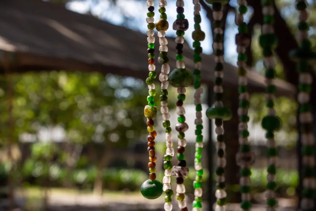 Strands of beads made from recycled glass hanging at a community craft workshop